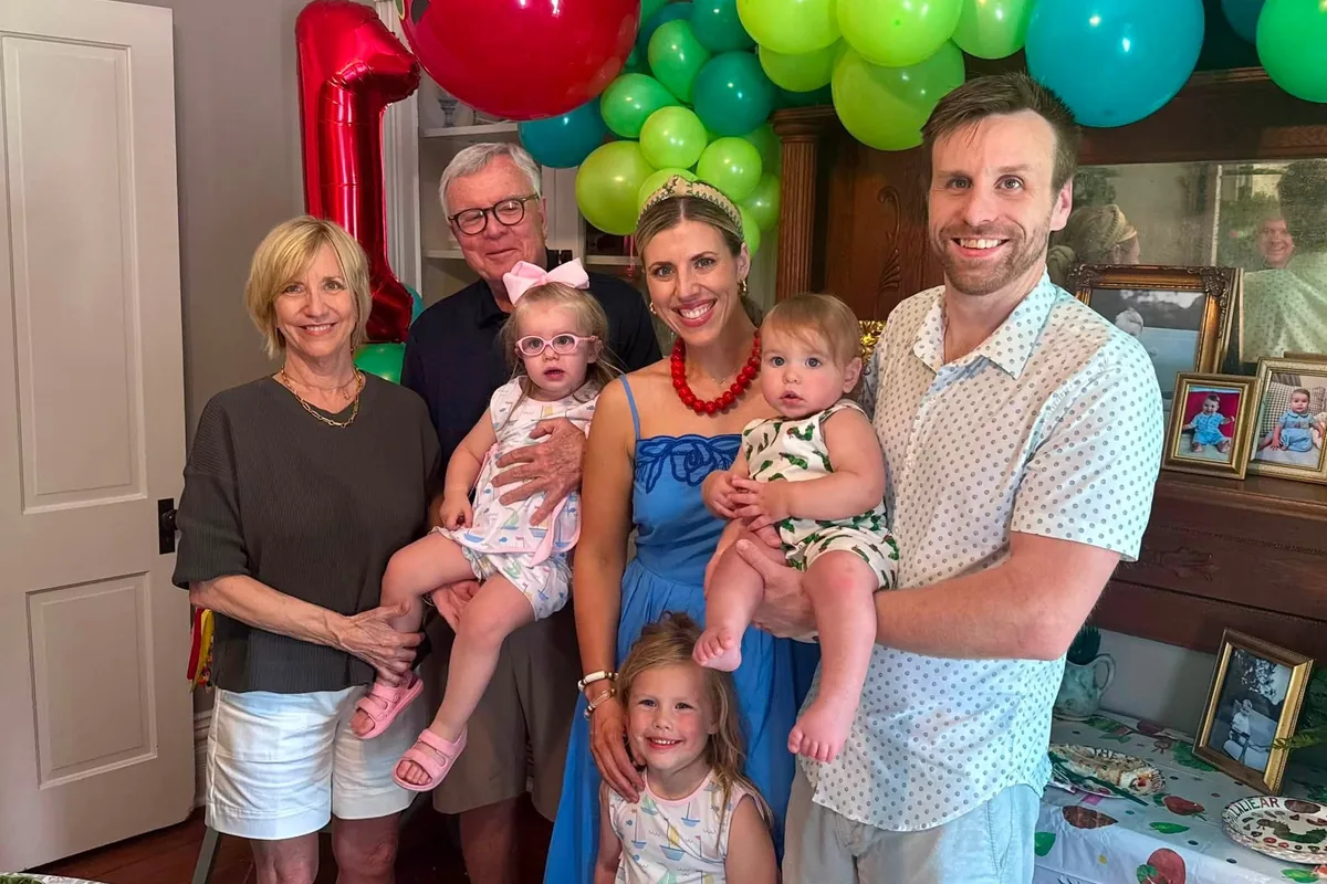 A multigenerational family gathered at home for a first birthday celebration